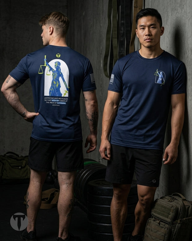 Two male models wearing a navy blue Titan 6 Men's Endure t-shirt in a gym setting, showing the front and back views. The back of the shirt features a large graphic of the Lady Justice holding a scale of justice, with the text 'JUSTICE RIGHTEOUS - JUSTICE WEARING'.