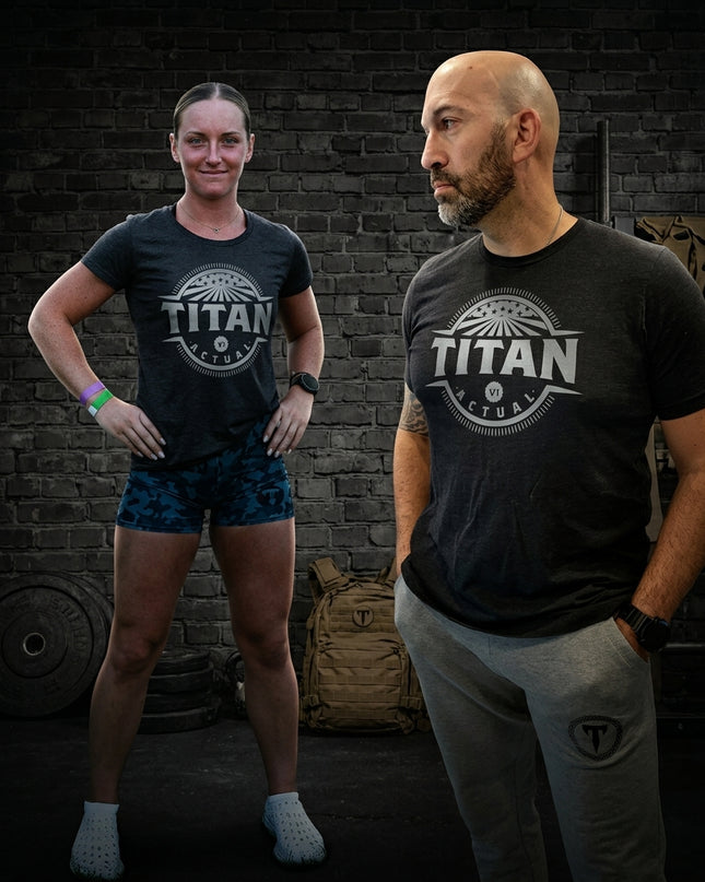 Titan 6 Actual Retro Nomad graphic tee worn with camo workout shorts and grey joggers in gym environment.