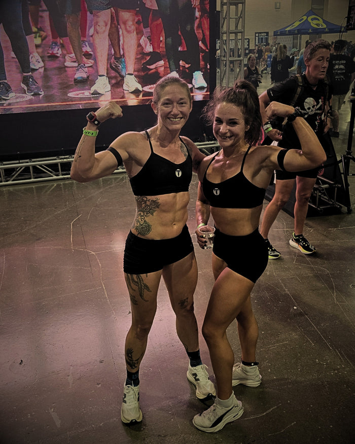 Titan 6 Athletes flexing at the Spartan DEKA FIT Ruck finish line in black sports bras and shorts.