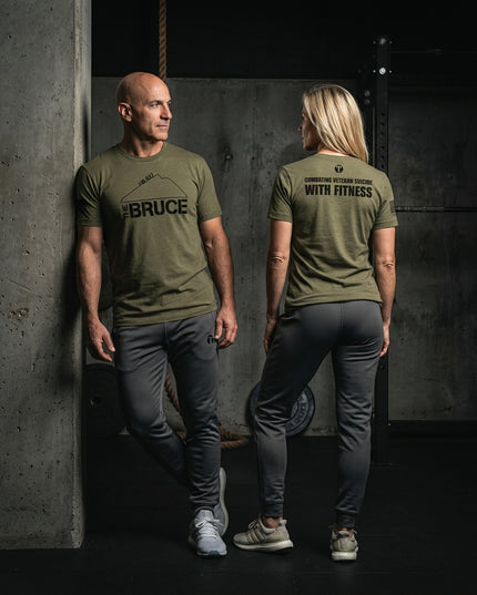 Titan 6 Actual Combatting Veteran Suicide With Fitness Bruce WOD graphic tee with grey joggers in gym environment.