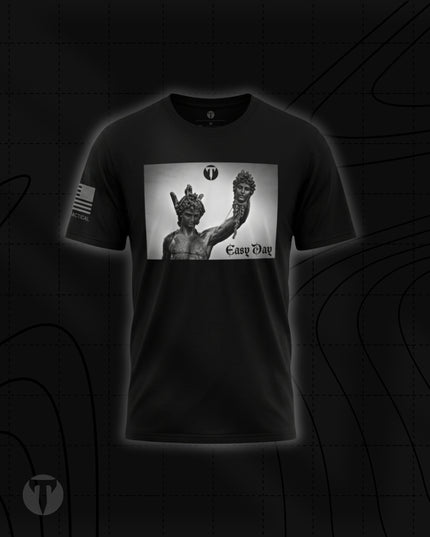 Front view of the Titan 6 Men's Endure T-Shirt in black, featuring a boxed chest graphic of the Perseus holding the head of Medusa statue alongside the text "Easy Day", a Titan 6 Icon logo, and an American flag printed on the right sleeve.