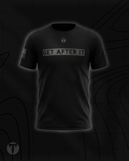 Front view of the Titan 6 Men's Endure T-Shirt in black, featuring the grey block-letter chest graphic "GET AFTER IT" below a small Titan 6 Icon logo and a monochromatic American flag printed on the right sleeve.