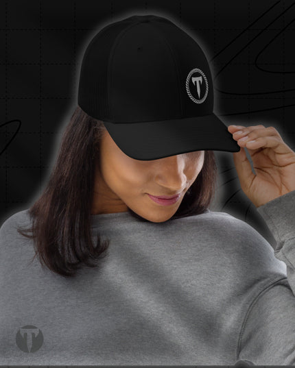 Woman wearing a grey sweatshirt and the Titan 6 Richardson 112 Trucker Snapback Cap in Black, featuring a silver Titan 6 Elite logo embroidered on the front left panel.