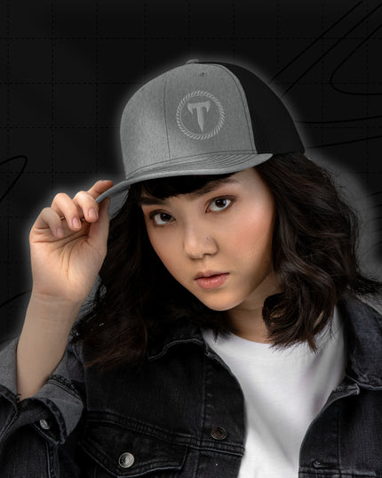 Woman wearing a black stonewash denim jacket and the Titan 6 Richardson 112 Trucker Snapback Cap in  gray and Black, featuring a silver Titan 6 Elite logo embroidered on the front left panel.