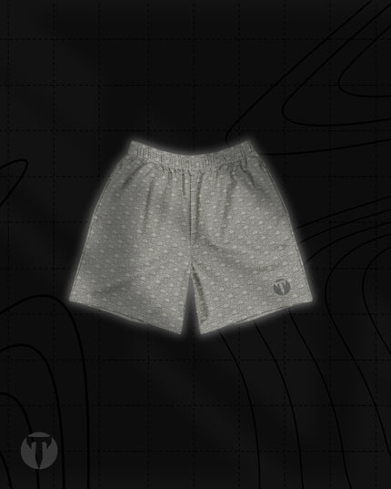 Front view of the Titan 6 Unisex Endure 6-Inch Linerless Shorts in Dragon's Den, featuring a light grey repeating skull and dragon graphic pattern with a dark Titan 6 Icon logo on the left leg hem.
