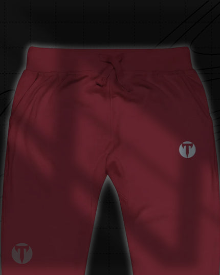 Titan 6 Unisex Garrison Jogger Icon in Light Maroon, featuring an elastic waistband with drawstrings and a silver circular "T" logo printed on the upper left thigh.