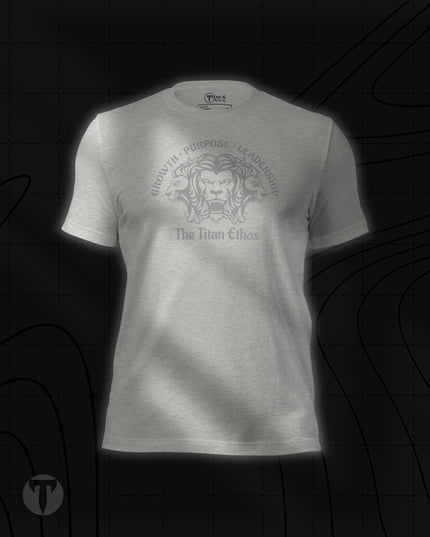 Titan 6 Unisex Nomad Tee in Athletic Heather, featuring a silver three-headed lion emblem with "GROWTH • PURPOSE • LEADERSHIP" arched above and "The Titan Ethos" printed below.