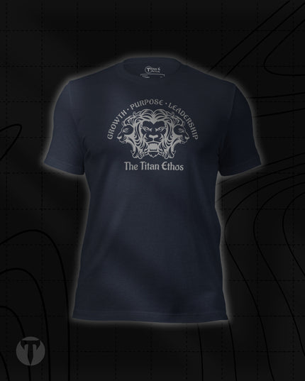 Titan 6 Unisex Nomad Tee in Heather Navy, featuring a silver three-headed lion emblem with "GROWTH • PURPOSE • LEADERSHIP" arched above and "The Titan Ethos" printed below.