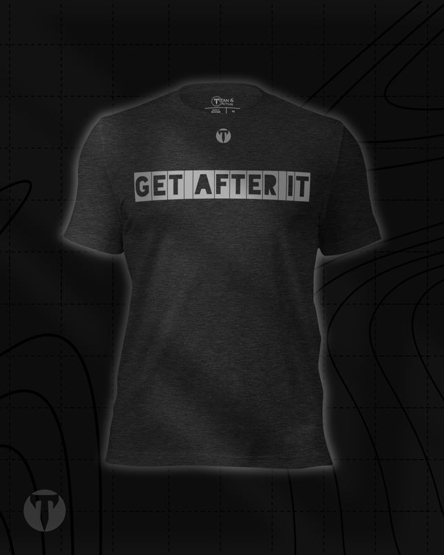 Titan 6 Unisex Nomad Tee in Dark Grey Heather, featuring "GET AFTER IT" printed across the chest in bold block letters, with a small "T" logo centered above it.