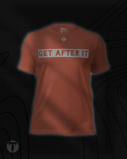 Titan 6 Unisex Nomad Tee in Heather Clay, featuring "GET AFTER IT" in stencil-style block lettering across the chest with a small "T" logo centered above it.