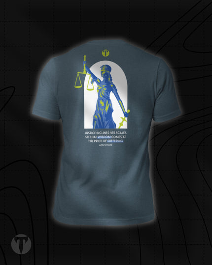 Back view of the Titan 6 Unisex Nomad Tee in Heather Slate, featuring a large Lady Justice graphic inside an arch with green highlights, accompanied by a quote from Aeschylus underneath: "JUSTICE INCLINES HER SCALES SO THAT WISDOM COMES AT THE PRICE OF SUFFERING".