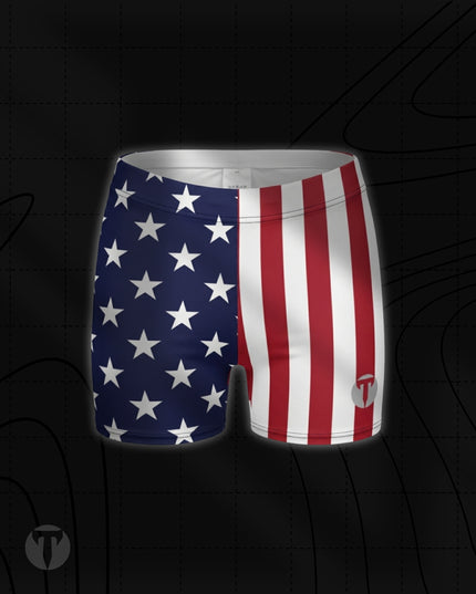 Titan 6 Women's Glide Shorts in Old Glory, featuring a split American flag design with white stars on blue on the right leg and red and white vertical stripes on the left leg with a grey "T" logo.