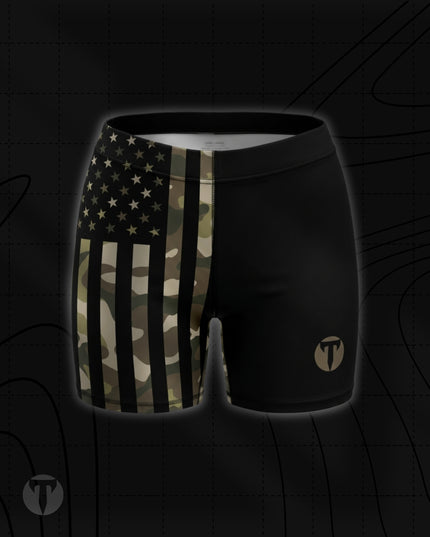 Titan 6 Women's Glide Shorts in Shadow Patriot, featuring a split design with a camouflage American flag print on the right leg and solid black on the left leg with a tan "T" logo.