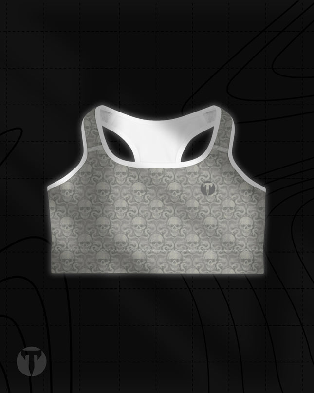 Titan 6 Women's Glide Sports Bra in Dragon's Den, featuring an all-over muted grey skull damask pattern with white trim and a small dark "T" logo on the left chest.