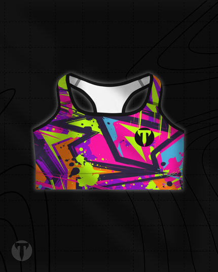 Titan 6 Women's Glide Sports Bra featuring a vibrant 90s-style abstract graffiti print in neon pink, lime green, purple, and blue, with a black "T" logo on the left chest.