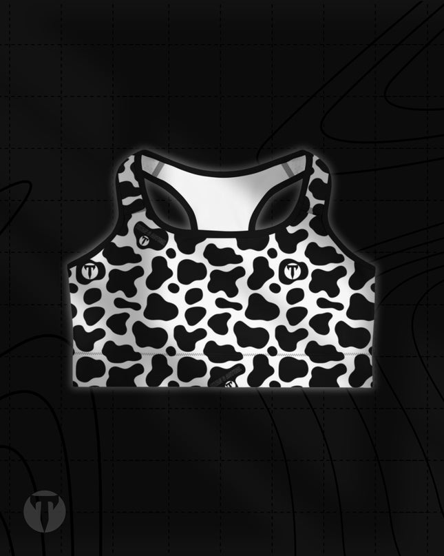 Titan 6 Women's Glide Sports Bra in Udder Chaos, featuring a black and white cow print pattern with a small white circular "T" logo on the right chest.